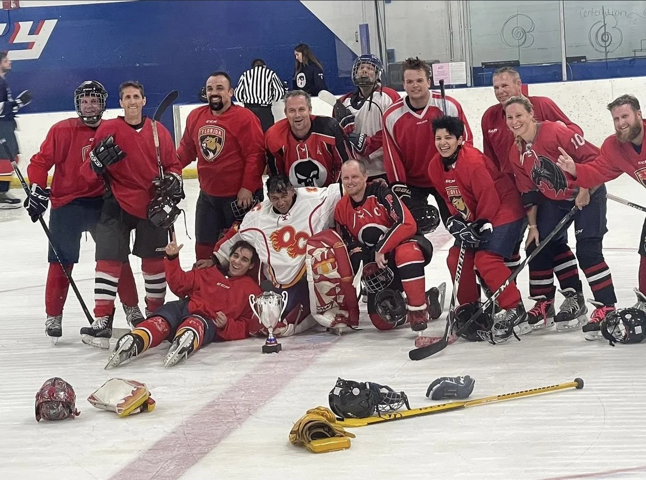 A group celebrating on the ice with a trophy