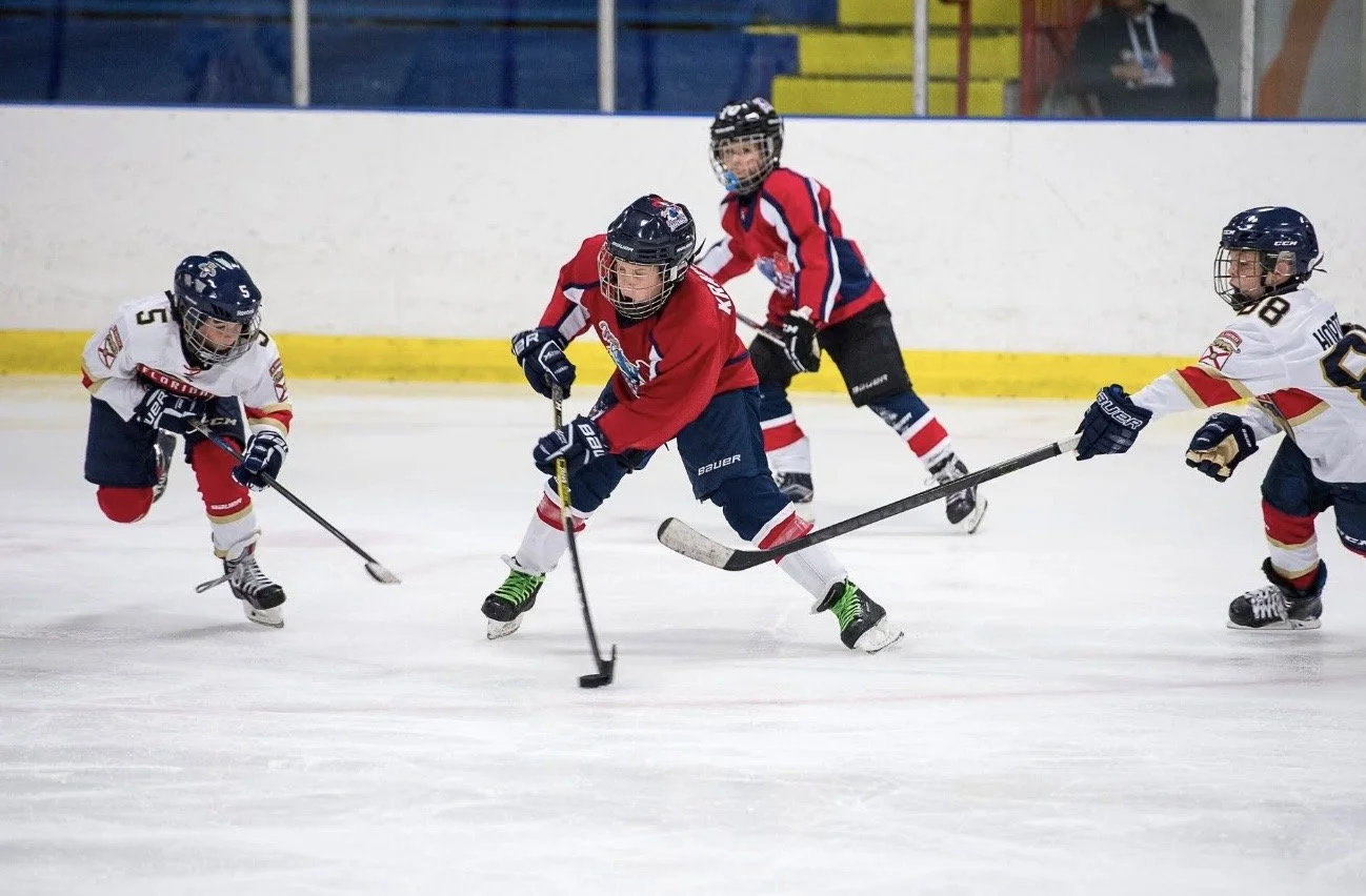 Youth hockey players battling for the puck at Miami Ice Arena